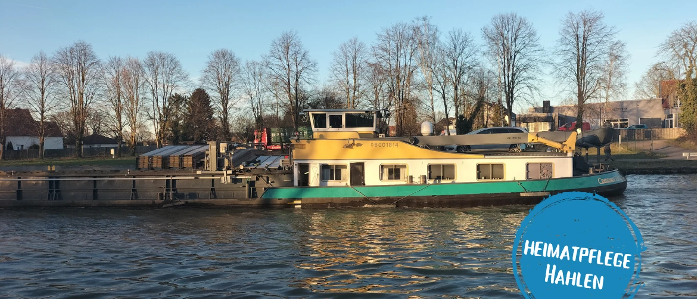 Minden - hahlen.png Das Bild zeigt den Mittellandkanal, auf dem ein Frachtschiff fährt.