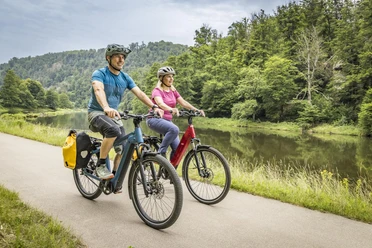 Am Regental-Radweg Zwei Radfahrer sind unterwegs auf dem Regental-Radweg und werden vom Flusslauf des Regens begleitet.