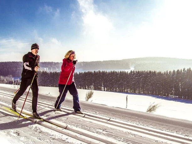 Zwei Langläufer in der Loipe vor toller Aussicht Zwei Langläufer in der Loipe vor toller Aussicht