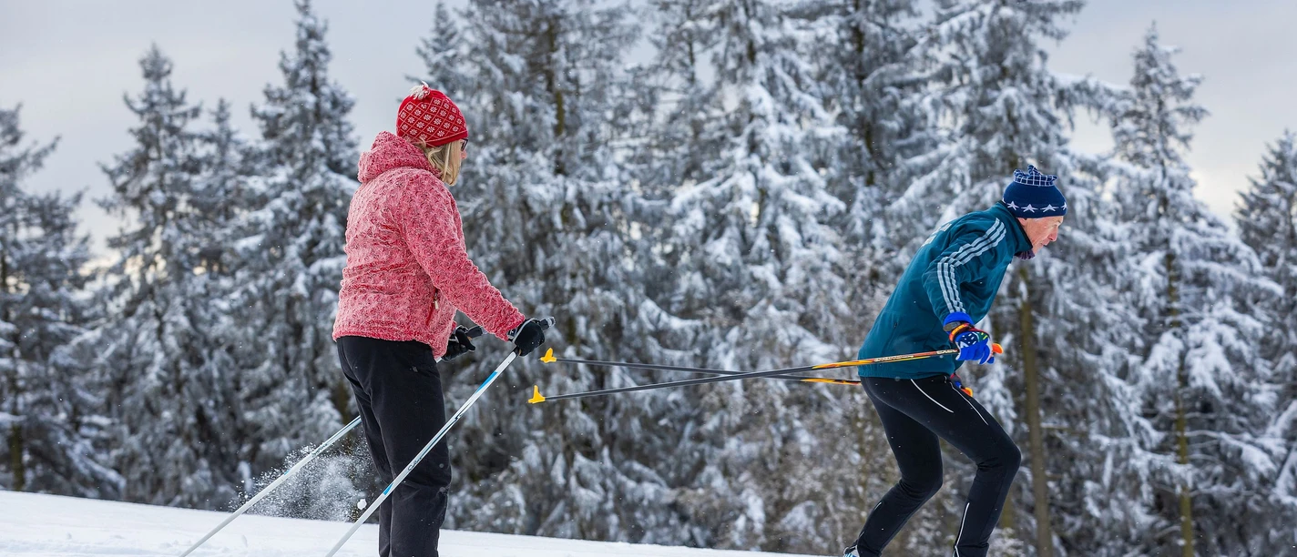 Langläufer-Paar auf der Abfahrt in der Loipe Langläufer-Paar auf der Abfahrt in der Loipe