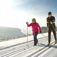 Zwei Langläufer in der Loipe vor toller Aussicht Zwei Langläufer in der Loipe vor toller Aussicht