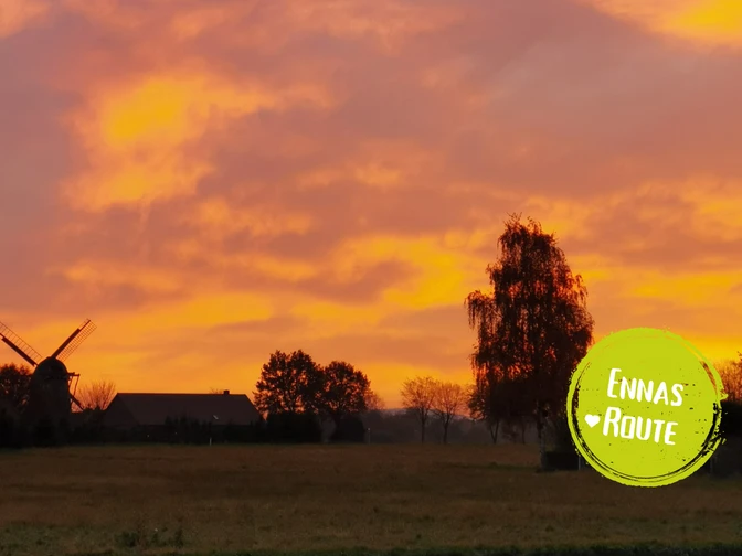 Das Bild zeigt eine dörfliche Landschaft in Abenddämmerung.