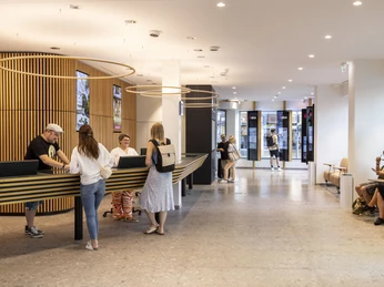 Tourist Information Cologne Besucher im modernen Foyer der Tourist-Information Köln am Tresen bei der Beratung.Visitors in the modern foyer of the Cologne Tourist Information Office at the counter for advice.