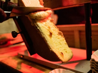 fabian stuertz 2022.12.15 - street kitchen 0093.jpg Fonduekäse wird auf Baguettescheiben in einer kleinen Schale gegossenFondue cheese is poured onto baguette slices in a small bowl.