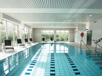 Schwimmbad mit Liegestühlen, im Hotel am Park Bad Driburg.