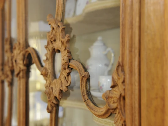 Großbürgerlicher Haushalt_Copyright_LVR-Industriemuseum_Foto Jürgen Hoffmann.jpg Holzgeschnitztes Vitrinendetail eines großbürgerlichen Haushalts, gefüllt mit feinem Porzellangeschirr.