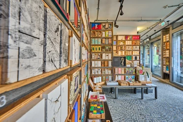Langenberg-Grundsteinkisten Voller Bücherschrank mit verschiedenfarbigen und -großen Büchern, modernes Interieur mit Mosaikboden.