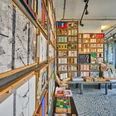 Langenberg-Grundsteinkisten Voller Bücherschrank mit verschiedenfarbigen und -großen Büchern, modernes Interieur mit Mosaikboden.