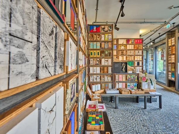 Langenberg-Grundsteinkisten Voller Bücherschrank mit verschiedenfarbigen und -großen Büchern, modernes Interieur mit Mosaikboden.