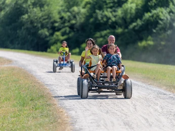 Monheim Landschaftspark Gocart Verleih Familie genießt Fahrt im Go-Kart auf einem staubigen Weg durch den Landschaftspark Monheim.