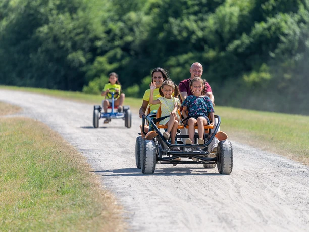 Monheim Landschaftspark Gocart Verleih Familie genießt Fahrt im Go-Kart auf einem staubigen Weg durch den Landschaftspark Monheim.