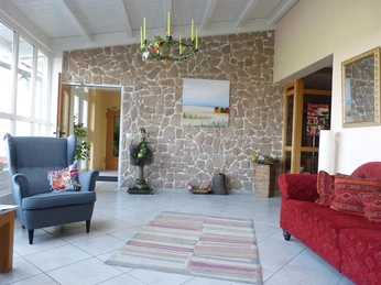 Großer Eingangsbereich mit Sitzgelegenheiten im Gästehaus Steker.