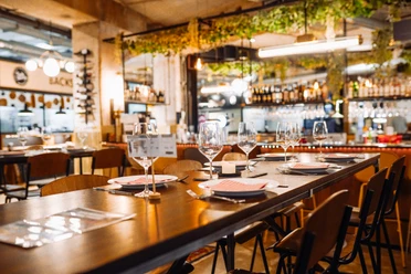 Bielefeld-Harms Markt-Teutoburger Wald-Bielefeld Marketing-Harms Markt Ein stilvoll gedeckter Tisch in einem modernen Restaurant, umgeben von gemütlicher Atmosphäre.