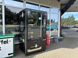 Regiomat Hühnerhof Terhorst Sustrum ©Emsland Tourismus GmbH (3).JPEG Schwarzer Lebensmittelautomat mit regionalen Produkten steht vor einem Hofladen im Emsland.