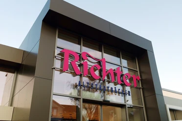 Close-up of an angular façade with large glass surfaces. Pink inscription: "Richter" underneath in blue: "Altstadtbäcker"