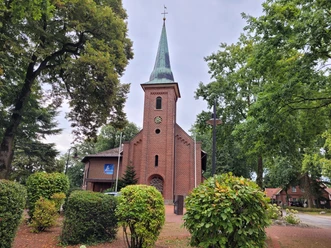 St. Martinus Kirche Lahn ©Emsland Tourismus GmbH.jpg Backsteinkirche mit hohem Turm und grünem Spitzdach, umgeben von Bäumen und gepflegten Sträuchern.