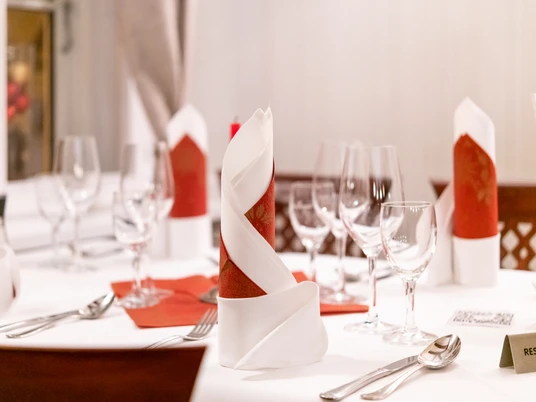 Da Giovanni Gastraum Edel gedeckter Tisch mit roten und weißen Stoffservietten