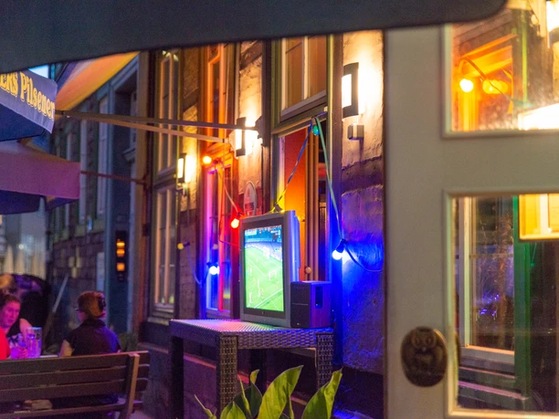 Illuminated outdoor area in the dark, soccer on TV