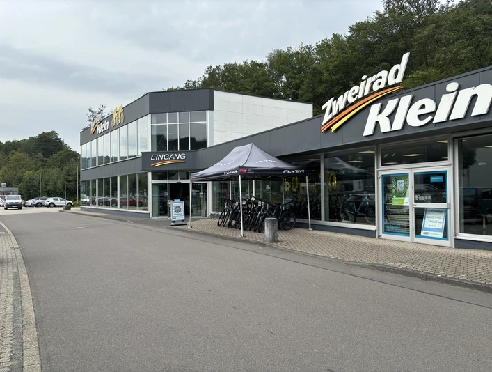 Zweirad Klein Zweiradgeschäft mit Fahrrädern vor dem Eingang und großen Fenstern, gelegen an einer ruhigen Straße.