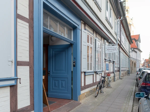 Hofcafé Eingang Geöffnete, zweiflügelige, blaue Tür in einem Fachwerkhaus. Am Haus hängt ei Schild auf dem "Hofcafé" steht.
