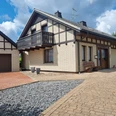 Ferienhaus Eggetal Fachwerk-Ferienhaus mit Balkon, Ziegeldach und gepflastertem Eingang, daneben ein Carport.