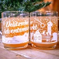 Delitzscher Adventsmarkt Punschglas Zusehen sind zwei Puschgläser mit dem Aufdruck "Delitzscher Adventsmarkt". Im Glas ist eine Puschähnliche Flüssigkeit.