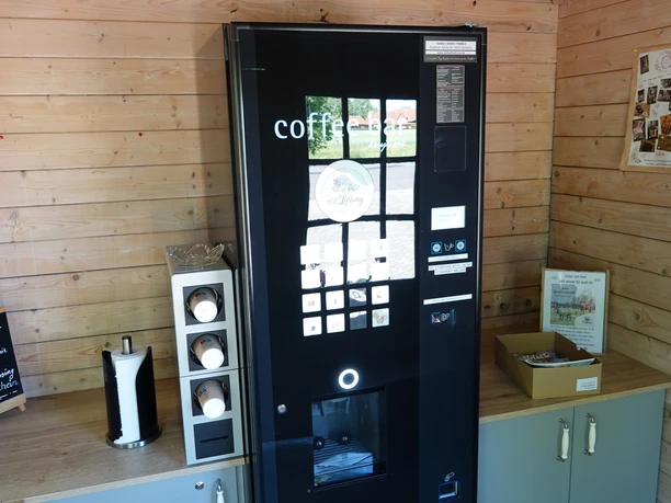 Selbstbedienungsautomat in Holzraum mit Kaffeemaschine, Bechern und Infomaterial vom Hof Lüssing.