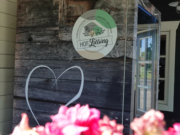 Regiomat Hof Lüssing ©Emsland Tourismus GmbH Regiomat des Hofs Lüssing mit Holzverkleidung und bunten Blumen im Vordergrund bei Sonnenschein