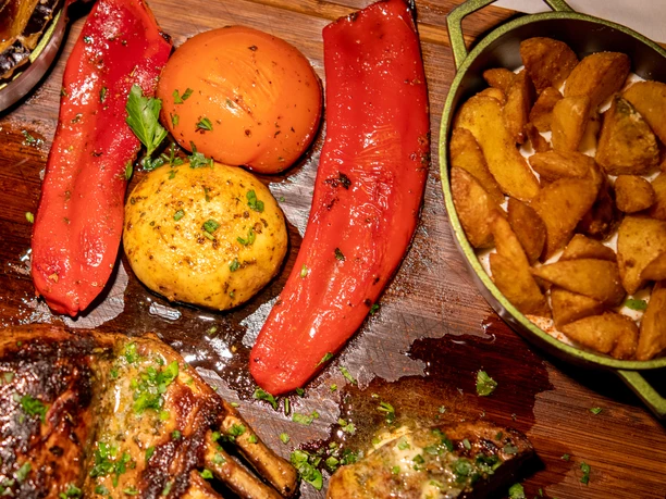 Rhodos Grillgericht Gebackene Kartoffeln, gegrillte Paprika, gegrilltes Fleisch und eine Auflaufform Kartoffelspalten