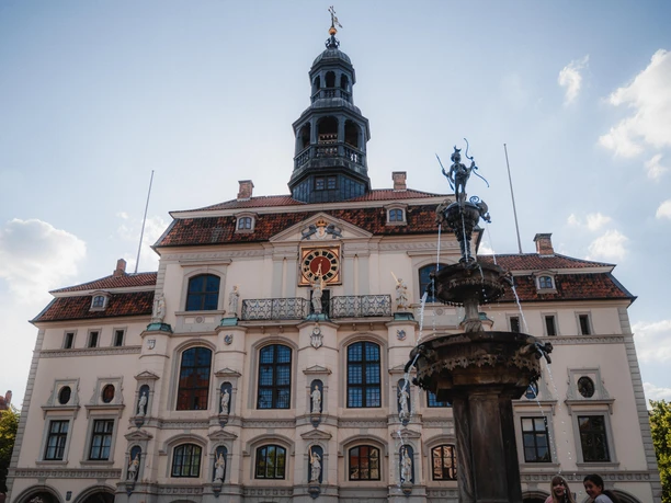 Het stadhuis van Lüneburg met zijn lichte gevel, standbeelden, klok en de Luna-fontein op de voorgrond.