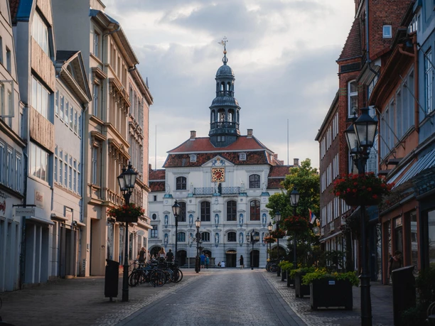 Uitzicht vanaf de straat op de witte gevel en de toren van het historische stadhuis van Lüneburg.