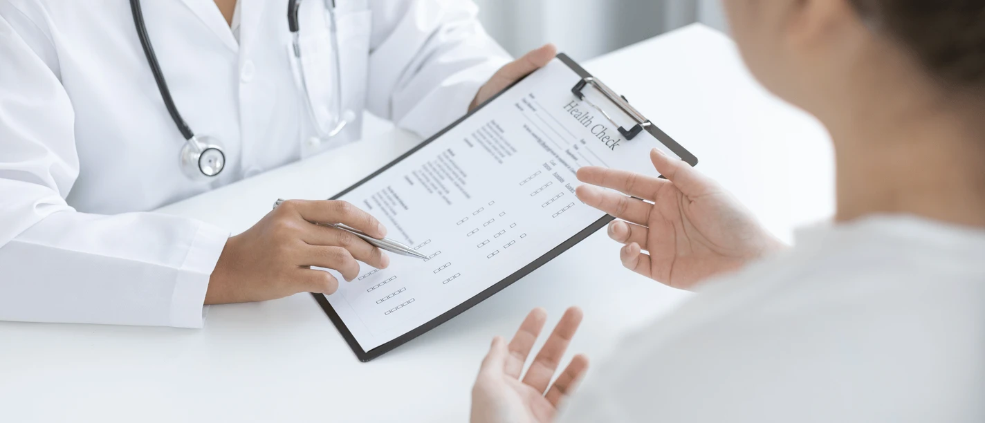 Badeärztin Inga Schmoor Symbolbild.png Auf dem Bild ist zu sehen, wie ein Arzt einem Patienten ein Formular zeigt und es ihm erklärt.