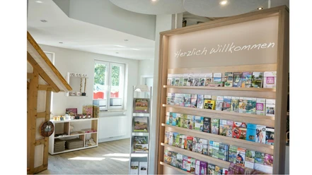 Tourist-Information-Bispingen-Lueneburger-Heide Tourist-Information im modernen Stil, mit Flyerregalen und "Herzlich Willkommen" Schriftzug.