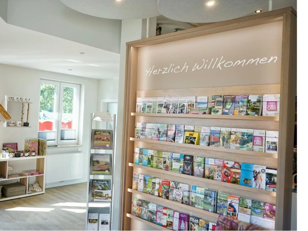 Tourist-Information-Bispingen-Lueneburger-Heide Tourist-Information im modernen Stil, mit Flyerregalen und "Herzlich Willkommen" Schriftzug.