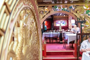 Wan Bao Gastraum Mit goldenen Ornamenten verzierter Gastraum mit rotem Teppichboden
