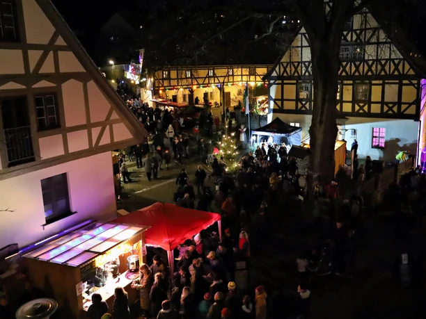Weihnachtsmarkt Hohnstein Weihnachtsmarkt in Hohnstein, abends beleuchtet, mit festlich geschmückten Fachwerkhäusern und bunten Buden.