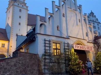 Colditzer Märchenschlossweihnacht Zusehen ist der Eingang von Schloss Colditz. Am Eingangstor sind zwei geschmückte Weihnachtsbäume aufgestellt und über der Tür hängt ein Banner mit der Aufschrift "Frohes Fest"You can see the entrance to Colditz Castle. Two decorated Christmas trees have been placed at the entrance gate and a banner with the words "Merry Christmas" hangs above the doorMůžete si prohlédnout vstup do hradu Colditz. U vstupní brány jsou umístěny dva ozdobené vánoční stromky a nad dveřmi visí transparent s nápisem "Veselé Vánoce".Widać wejście do zamku Colditz. Przy bramie wejściowej ustawiono dwie udekorowane choinki, a nad drzwiami wisi baner z napisem "Wesołych Świąt".Je kunt de ingang van Kasteel Colditz zien. Twee versierde kerstbomen zijn geplaatst bij de toegangspoort en een spandoek met de woorden "Merry Christmas" (Vrolijk Kerstfeest) hangt boven de deur.Si vede l'ingresso del castello di Colditz. Due alberi di Natale decorati sono stati collocati al cancello d'ingresso e uno striscione con la scritta "Merry Christmas" è appeso sopra la porta.