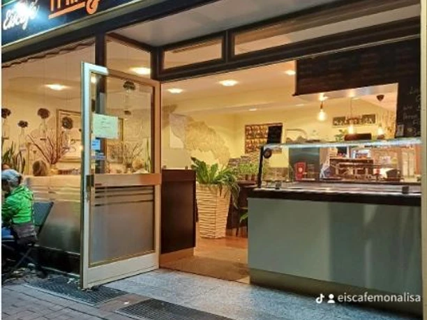 Eiscafé Mona Lisa mit einladender offener Fassade und gut beleuchtetem Innenraum in Abendstimmung.