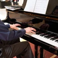 kurkonzert-bad-zwischenahn Musiker spielt am schwarzen Flügel im Kurhaus Bad Zwischenahn ein klassisches Konzertstück.