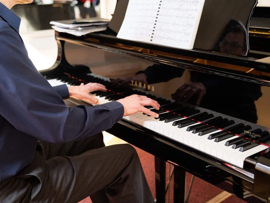 kurkonzert-bad-zwischenahn Musiker spielt am schwarzen Flügel im Kurhaus Bad Zwischenahn ein klassisches Konzertstück.