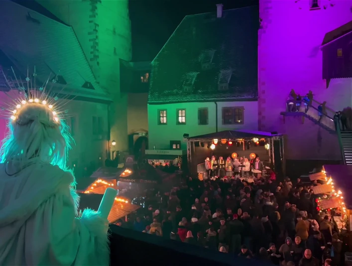 Rochlitzer Schlossweihnacht Zusehen ist der Innenhof von Schloss Rochlitz mit der Schlossweihnacht. Am Bildrand ist ein Engel.