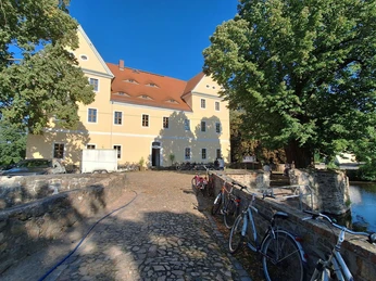 11 - Supervulkan-Zentrum R├Âcknitz - ehamliges Rittergut - Foto Kathleen Schramm.jpg Ehemaliges Rittergut, gelbes Gebäude mit rotem Dach, umgeben von Bäumen, Fahrräder am Weg.Former manor, yellow building with red roof, surrounded by trees, bicycles along the path.Bývalý zámeček, žlutá budova s červenou střechou, obklopená stromy, podél cesty kola.Dawny dwór, żółty budynek z czerwonym dachem, otoczony drzewami, rowery wzdłuż ścieżki.Voormalig landhuis, geel gebouw met rood dak, omringd door bomen, fietsen langs het pad.Ex maniero, edificio giallo con tetto rosso, circondato da alberi, biciclette lungo il sentiero.