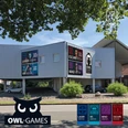 Außenansicht OWL Games Zweistöckiges Gebäude mit auffälligen Werbeschildern für Laser Arena, Escape Room und mehr.