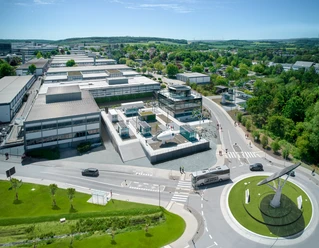 Luftaufnahme des All Electric Society Parks in Blomberg mit Gebäudekomplex und grünem Umland.