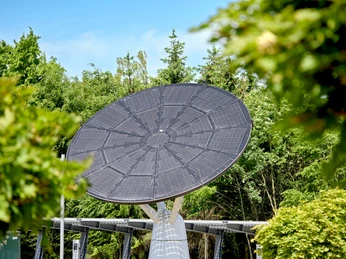 Solaranlage im All Electric Society Park Blomberg, umgeben von grüner Vegetation und klarem Himmel.