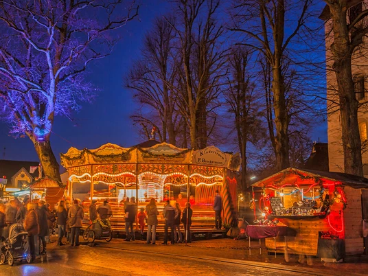 Hamberger Weihnachtsmarkt Beleuchtetes Karussell und Marktstände mit Besuchern auf dem Hamberger Weihnachtsmarkt bei Nacht.Illuminated carousel and market stalls with visitors at the Hamberg Christmas market at night.Oplyst karrusel og markedsboder med besøgende på Hambergs julemarked om aftenen.Verlichte draaimolen en marktkramen met bezoekers op de Hambergse kerstmarkt bij nacht.