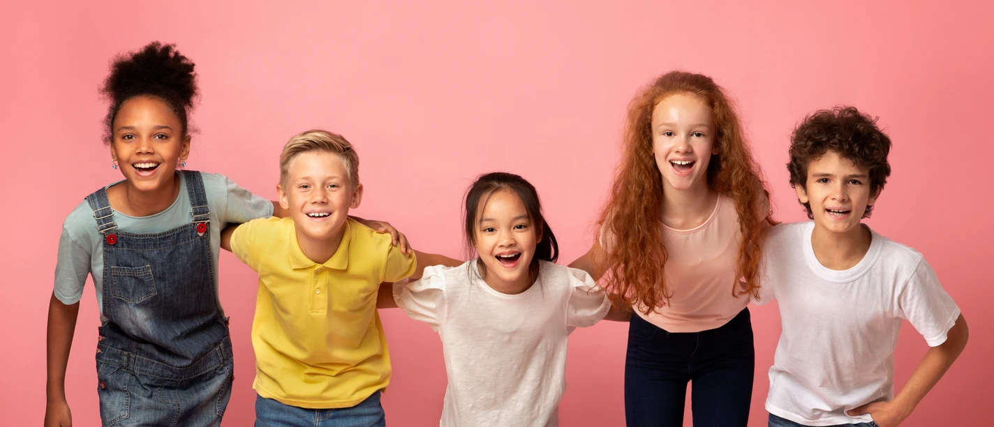 Portrait of multiethnic schoolkids smiling on pink background Portrait of multiethnic schoolkids smiling on pink background
