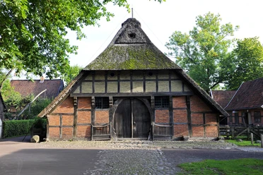 Historisches Fachwerk-Bauernhaus mit Reetdach und großem Holztor in Bad Zwischenahn.