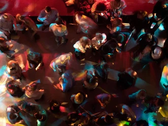 Club_Party_Pixabay.jpg Vogelperspektive auf Menschen, die lebhaft unter buntem Licht auf einer belebten Tanzfläche tanzen.