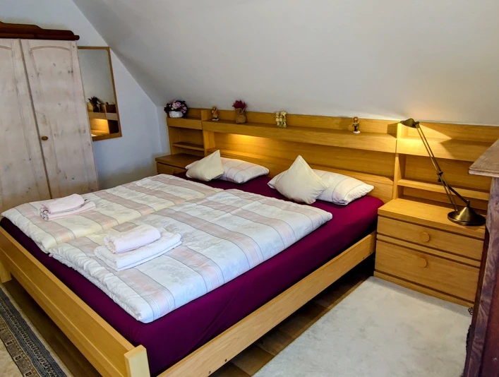 Haus am Park 1 (C) Gaby Schramm.jpg Gemütliches Schlafzimmer mit einem Doppelbett, Nachttischen, einer Kommode und einem Kleiderschrank.